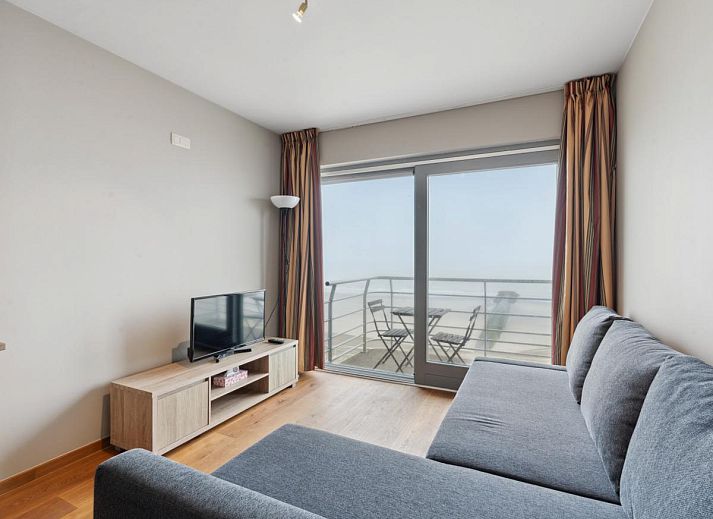 Gezellig woonkamerinterieur van Ocean Suites - 1004, vakantiehuis aan de Belgische kust in Blankenberge, met uitzicht op het terras.