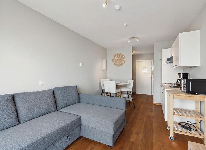Gezellig woonkamerinterieur van Ocean Suites - 1004, vakantiehuis aan de Belgische kust in Blankenberge, met uitzicht op het terras.