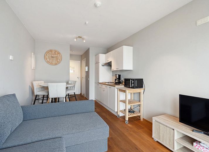 Gezellig woonkamerinterieur van Ocean Suites - 1004, vakantiehuis aan de Belgische kust in Blankenberge, met uitzicht op het terras.