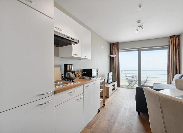 Gezellige woonkamer van Ocean Suites - 1004 in Blankenberge, Belgische kust, met uitzicht op zee vanaf het balkon van dit vakantieappartement.