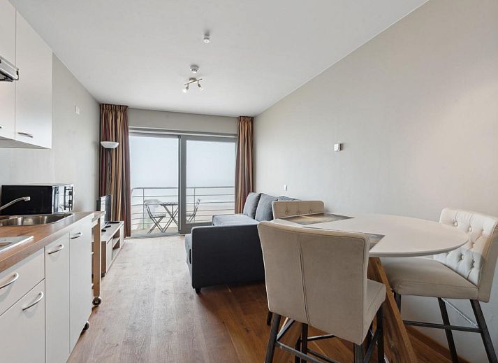Gezellige woonkamer van Ocean Suites - 1004 in Blankenberge, Belgische kust, met uitzicht op zee vanaf het balkon van dit vakantieappartement.