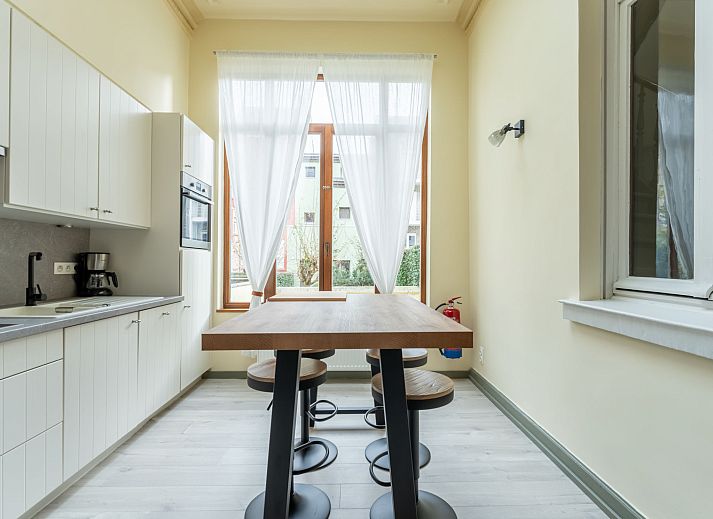 Ontdek de elegante eetkamer van Vakantiehuis Notre Refuge in Blankenberge, Belgische kust, een perfecte Belle Epoque escape.