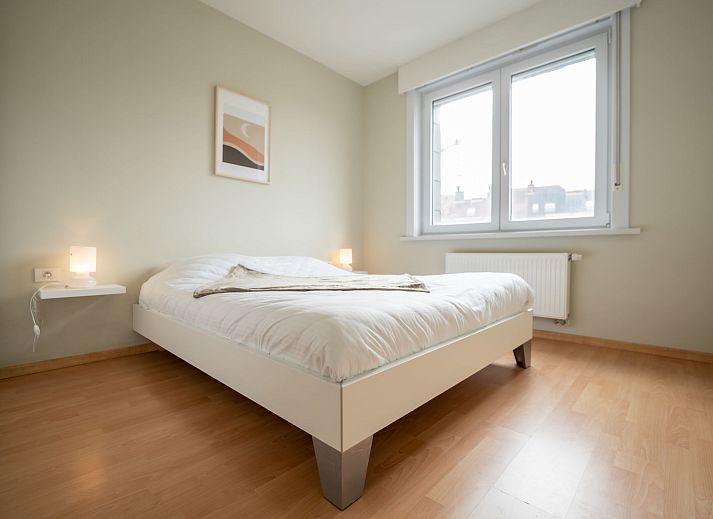 Sfeervolle slaapkamer in Appartement Andrei met parkeergelegenheid in Blankenberge aan de Belgische kust, ideaal voor een ontspannen verblijf.