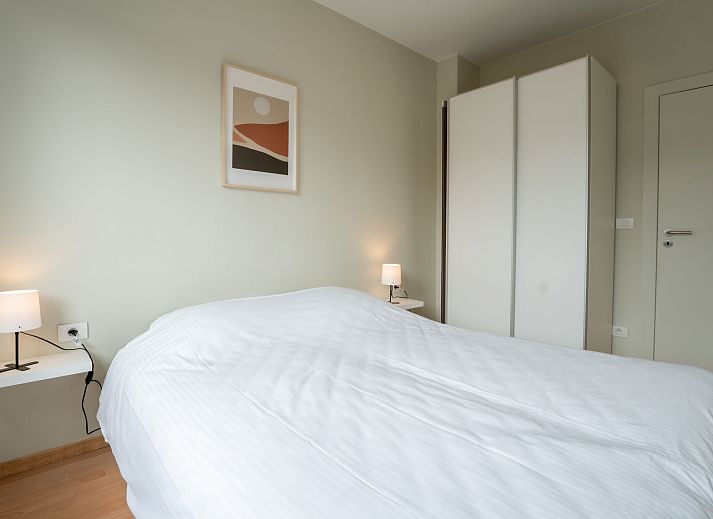 Sfeervolle slaapkamer in Appartement Andrei met parkeergelegenheid in Blankenberge aan de Belgische kust, ideaal voor een ontspannen verblijf.