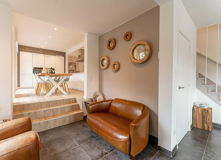 Stijlvolle binnenruimte van La Ciotat, een vakantiehuis in Koksijde, Belgische kust, met comfortabele leren stoelen en veel daglicht.