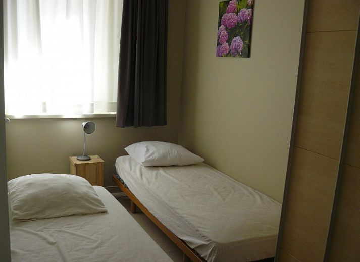 Gezellige woonkamer in Symfonie - Residentie appartement, Koksijde, met comfortabele banken en uitzicht op het terras.