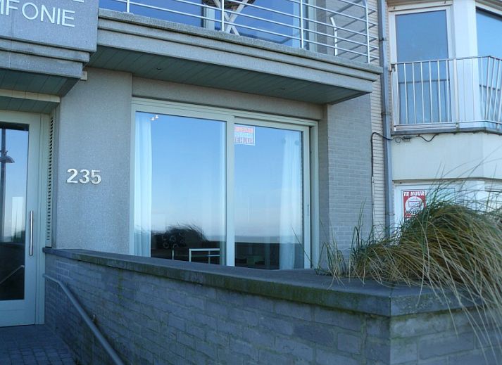 Gezellige woonkamer in Symfonie - Residentie appartement, Koksijde, met comfortabele banken en uitzicht op het terras.