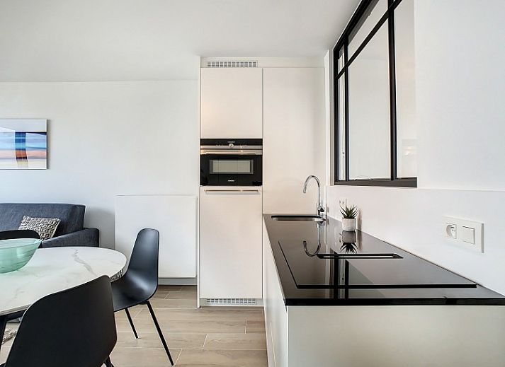Moderne eetkamer in Penthouse 'Kinkhoorn', Koksijde aan de Belgische kust, met stijlvol interieur en veel natuurlijk licht.