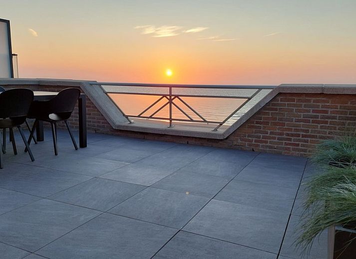 Penthouse 'Kinkhoorn' in Koksijde, Belgie biedt een moderne woonkamer met uitzicht op zee, perfect voor een ontspannen vakantie aan de kust.