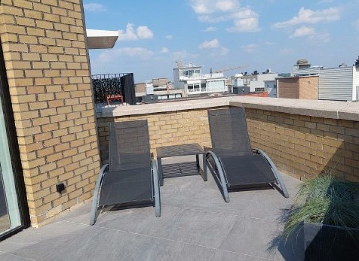 Penthouse 'Kinkhoorn' in Koksijde, Belgie biedt een moderne woonkamer met uitzicht op zee, perfect voor een ontspannen vakantie aan de kust.