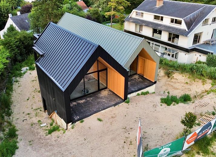 Moderne vrijstaande woning in Koksijde aan de Belgische kust, vakantiehuis met glazen gevel en uitzicht op groene omgeving.
