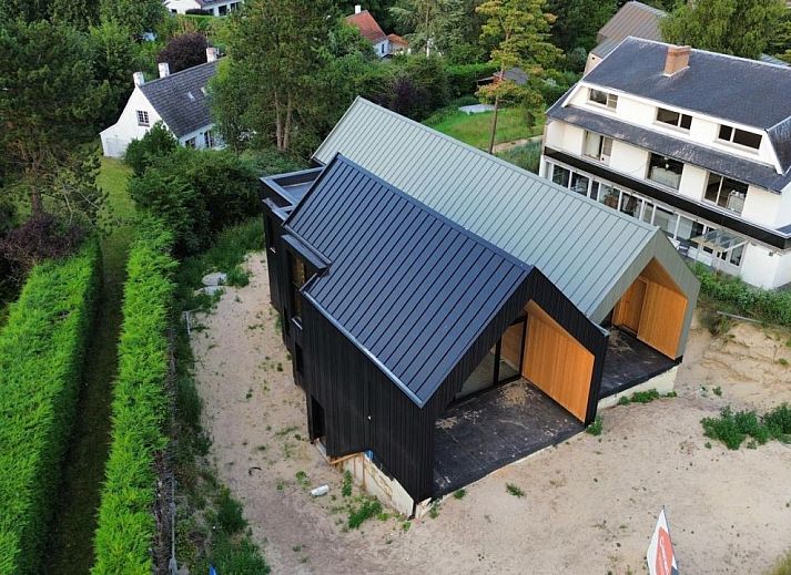 Vrijstaande woning in Koksijde aan de Belgische kust, modern vakantiehuis omringd door groene natuur en serene omgeving.
