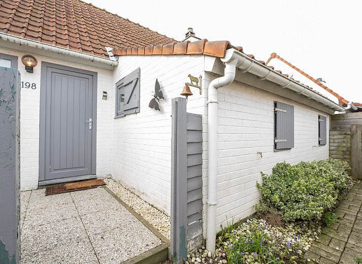 Sfeervolle slaapkamer in Vakantiehuis Zeewind II in Bredene, Belgische kust, met houten balken en zacht beddengoed voor een rustgevend verblijf.