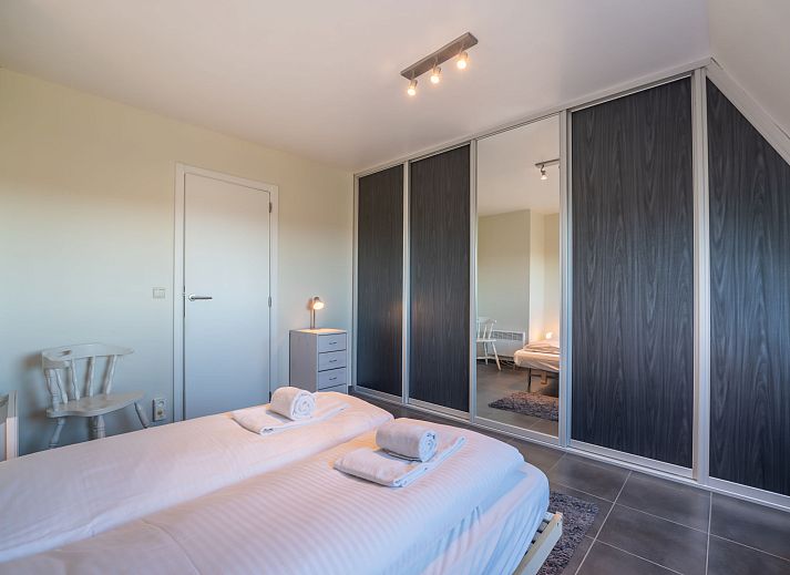 Modern kitchen in Apartment Marebelle, vacation rental in Bredene on the Belgian coast, fitted with sleek white cabinets and appliances.