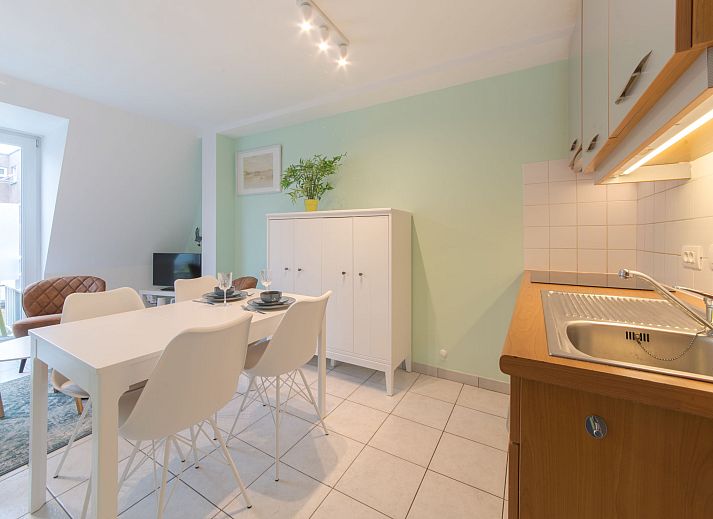Gezellige woonkamer en keuken in Appartement Ter Duinen, een vakantieverblijf aan de Belgische kust in Bredene, perfect voor ontspanning.