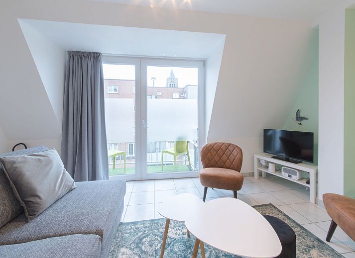 Gezellige woonkamer en keuken in Appartement Ter Duinen, een vakantieverblijf aan de Belgische kust in Bredene, perfect voor ontspanning.