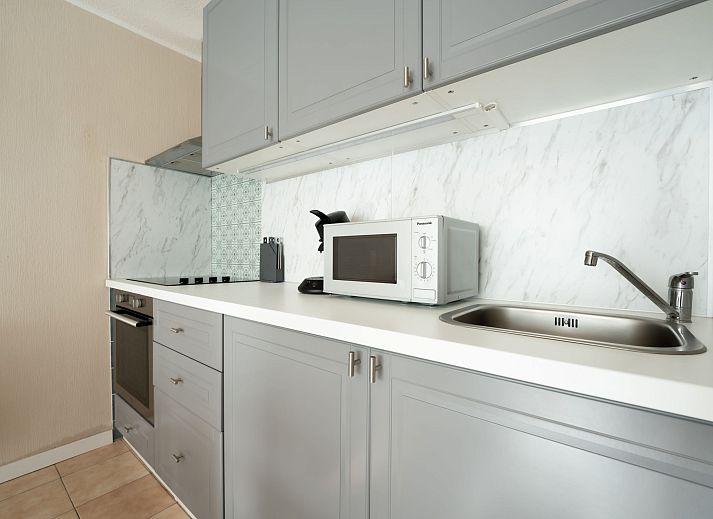 Cozy interior space of Apartment Astrid 62/ 101 in Bredene, Belgian coast, with modern kitchen and sunny dining area.