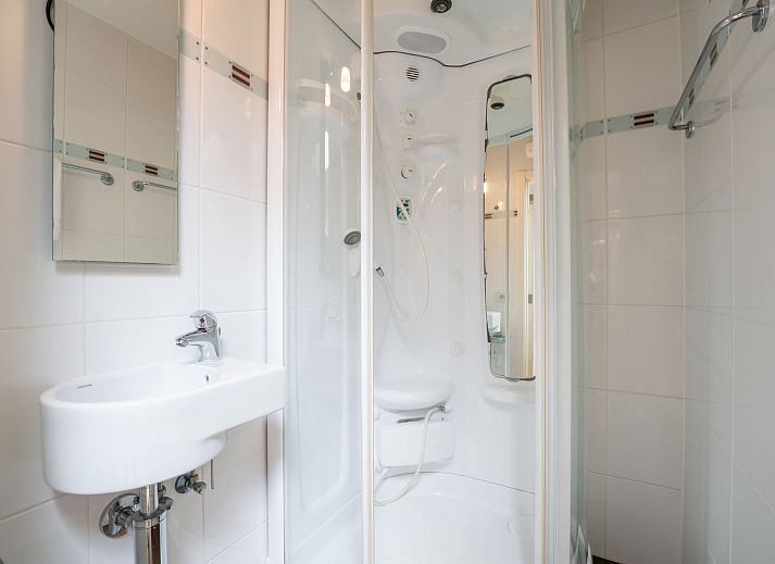 Dining room of Apartment Queen Mary in Bredene, Belgian coast. Cozy space with wooden table and art on the wall for a relaxing stay.