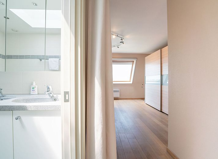 Dining room of Apartment Queen Mary in Bredene, Belgian coast. Cozy space with wooden table and art on the wall for a relaxing stay.