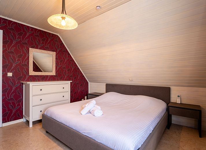 Gemuetliches Wohnzimmer des Ferienhauses Villa Zeebries in Bredene, belgische Kueste, mit Kamin und Gartenblick.