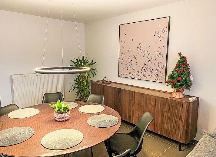 Cozy living room of Apartment Ocean in Bredene, Belgian coast, overlooking nature through large windows.
