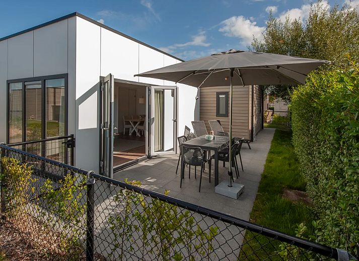 Enjoy the sunny terrace of Chalet in Bredene, a vacation home on the Belgian coast with modern outdoor space and comfortable seating.