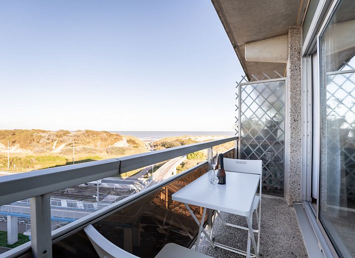 Bright living room of Apartment Studio 62-705 in Bredene, Belgian coast, overlooking dunes and modern furnishings.