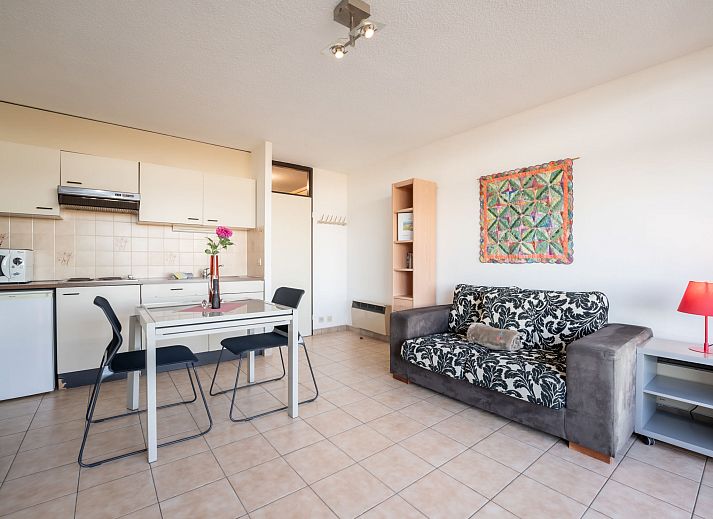 Bright living room of Apartment Studio 62-705 in Bredene, Belgian coast, overlooking dunes and modern furnishings.
