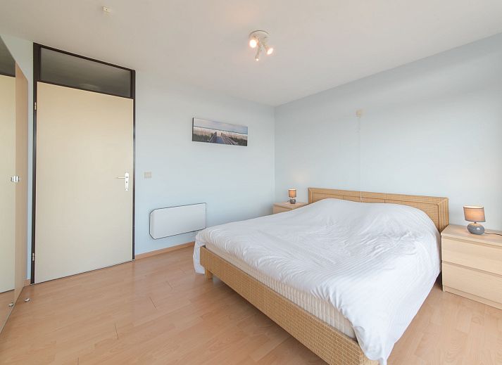 View from the balcony of Apartment Residence Astrid in Bredene on the Belgian coast, with green parks and the sea in the distance.