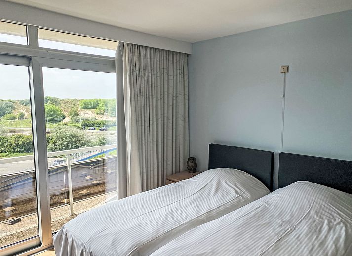 View from the balcony of Apartment Residence Astrid in Bredene on the Belgian coast, with green parks and the sea in the distance.