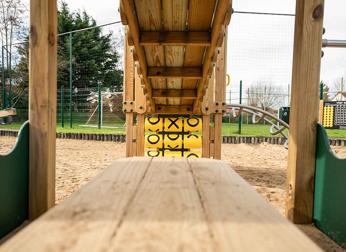 Gemuetliches Schlafzimmer im Ferienhaus Vissershuis 214, Bredene, belgische Kueste, mit rustikaler Holzdecke und stimmungsvollem Tageslicht.