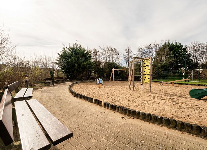 Ontspan in de groene tuin van Vakantiehuis Zeewind 145 in Bredene aan de Belgische kust, met comfortabele ligstoelen en een rustgevende sfeer.