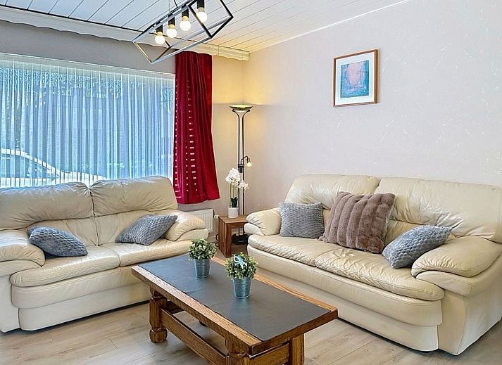 Gezellige woonkamer van Vakantiehuis Ruiterlaan in Bredene, Belgische kust, met comfortabele banken en een ruime eethoek.