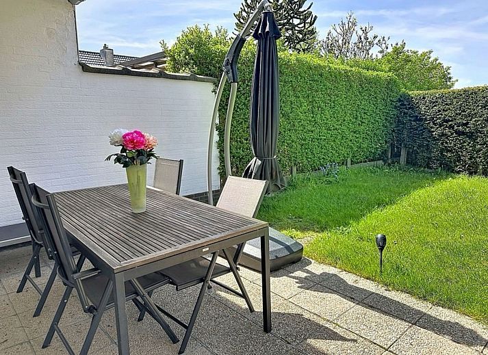 Gezellige woonkamer van Vakantiehuis Ruiterlaan in Bredene, Belgische kust, met comfortabele banken en een ruime eethoek.