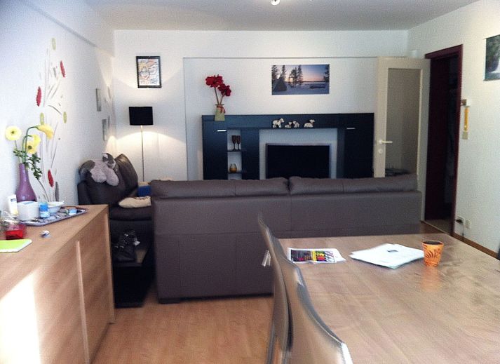 Cozy living room of Appartement Wohnung 'Wie zu Hause' in Middelkerke, Belgian coast, with comfortable sofa and colorful wall decoration.