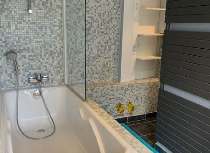 Gezellige woonkamer in Vakantiehuis RUST, Middelkerke, Belgische kust, met comfortabele zithoek en groot raam.