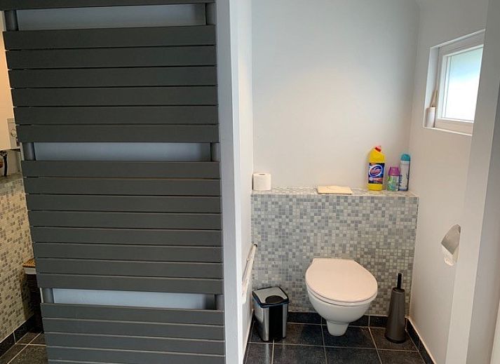Gezellige woonkamer in Vakantiehuis RUST, Middelkerke, Belgische kust, met comfortabele zithoek en groot raam.