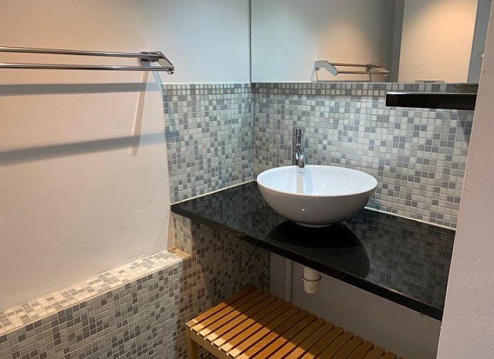 Ruime eetkamer met houten tafel in Vakantiehuis RUST, Middelkerke, Belgische kust, uitzicht op kleurrijke muurschildering.