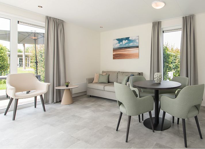 Moderne woonkamer in Access Lodge, vakantiehuis in Westende, Belgische kust, met stijlvolle inrichting en uitzicht op de groene omgeving.