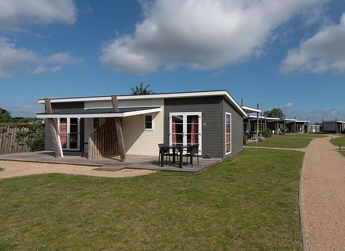 Comfort Lodge in Westende, Belgische kust, biedt een charmante vakantie-ervaring met een ruime veranda en groene omgeving.