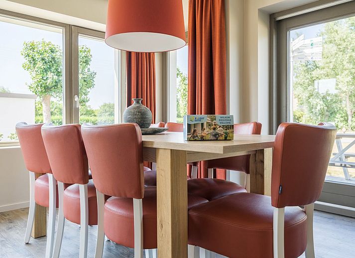 Terrasuitzicht vanuit de Ruime Familiesuite in Westende, Belgische kust, met toegang tot groene omgeving.