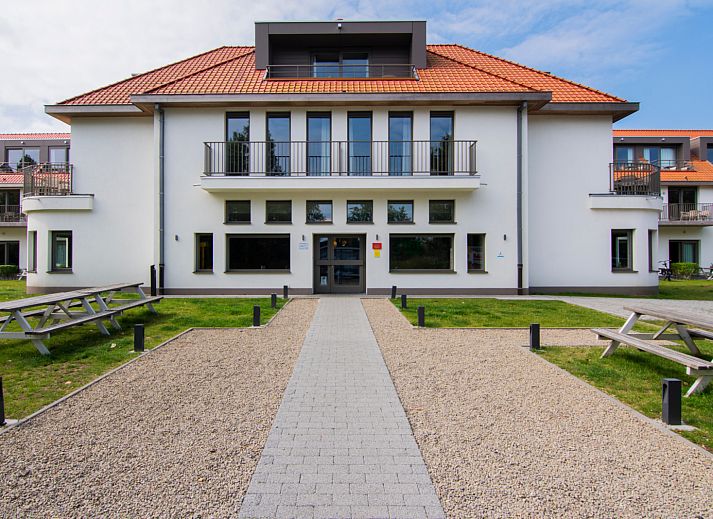 Gezellige slaapkamer met balkon in Ruime Familiesuite, Westende, Belgische kust, met uitzicht op speeltuin.