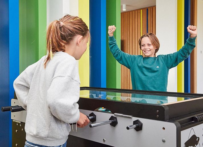 Gezellige slaapkamer met balkon in Ruime Familiesuite, Westende, Belgische kust, met uitzicht op speeltuin.