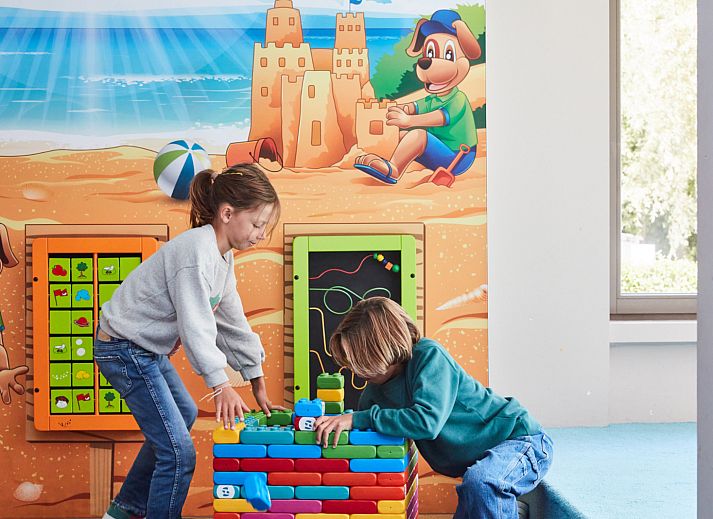Gezellige slaapkamer met balkon in Ruime Familiesuite, Westende, Belgische kust, met uitzicht op speeltuin.