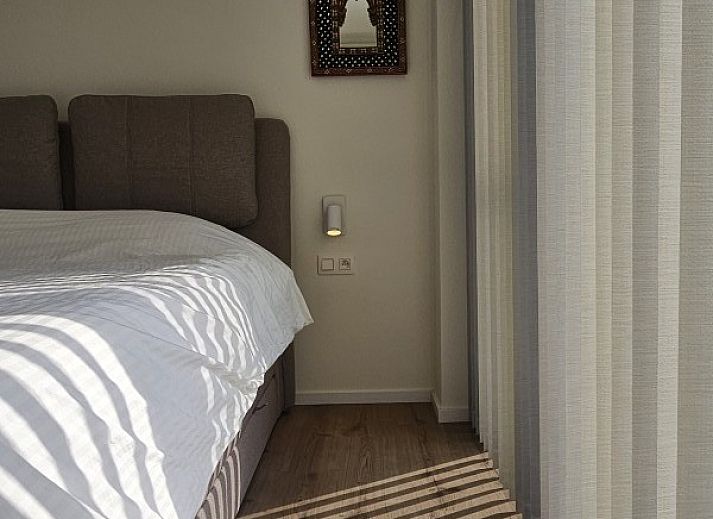 Gezellige zithoek in 't Zeehuisje, Westende: comfortabele bank met decoratieve kussens en wandkunst aan de Belgische kust.