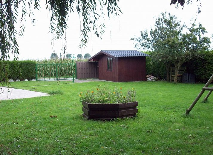 Gezellige binnenruimte van vakantiehuis Cobergh in Veurne met rode bank en houten details.