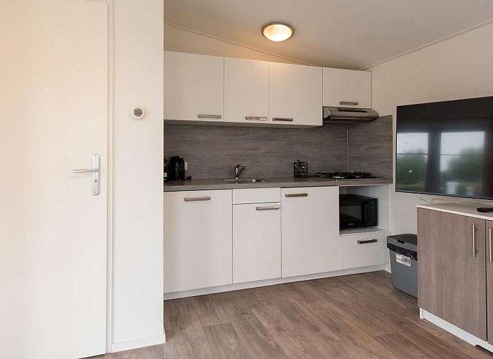 Comfort Lodge in Nieuwpoort, Belgische kust, biedt een moderne binnenruimte met airco en uitzicht op de tuin, ideaal voor een ontspannen verblijf.