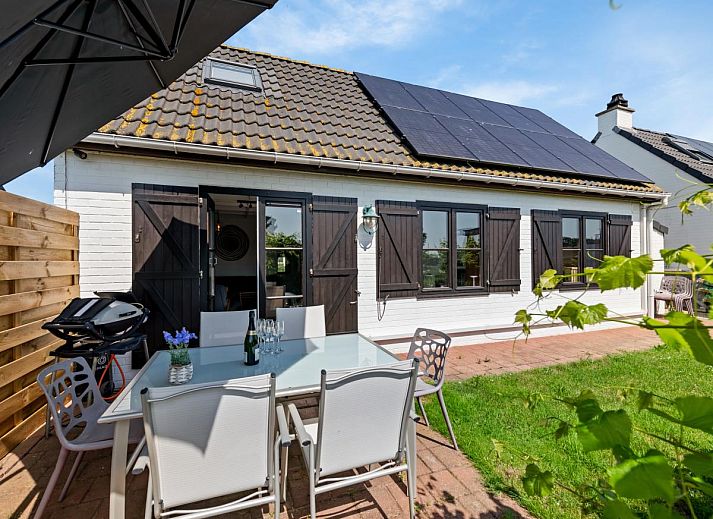 Nieuwendamme 008 vakantiehuis in Nieuwpoort, Belgische kust, omgeven door bloeiende bloemen en een zonnige blauwe lucht.