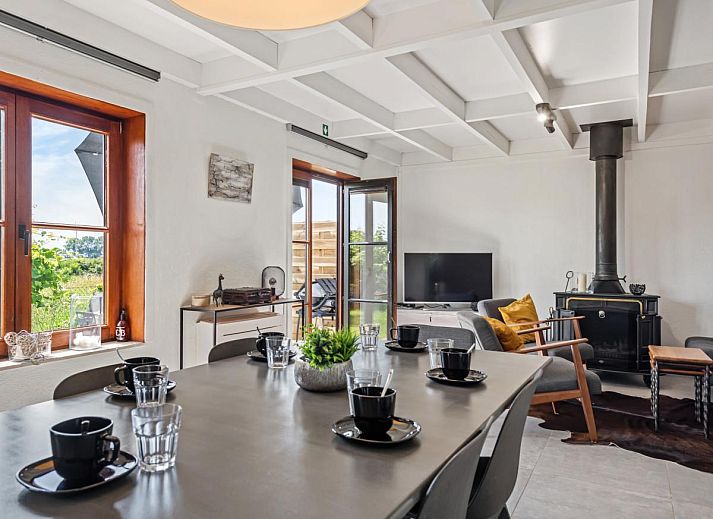 Gezellige woonkamer van vakantiehuis Nieuwendamme 008 in Nieuwpoort, Belgische kust, met moderne inrichting en uitzicht op terras.