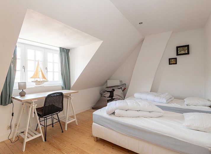 Gezellige woonkamer in vakantiehuis Notre Dame, Nieuwpoort, Belgische kust met comfortabele zithoek en houtkachel.